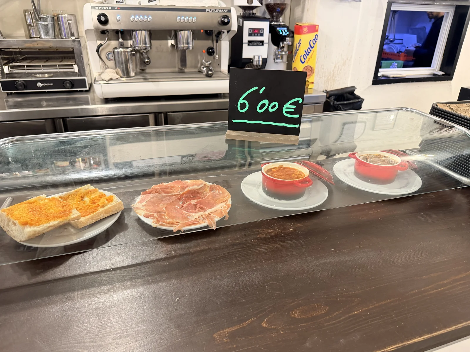 Mollete, jamón y cacerolas en la barra